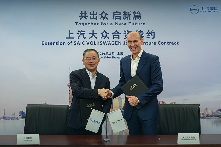 Executives from SAIC Motor and Volkswagen shake hands. 1.png