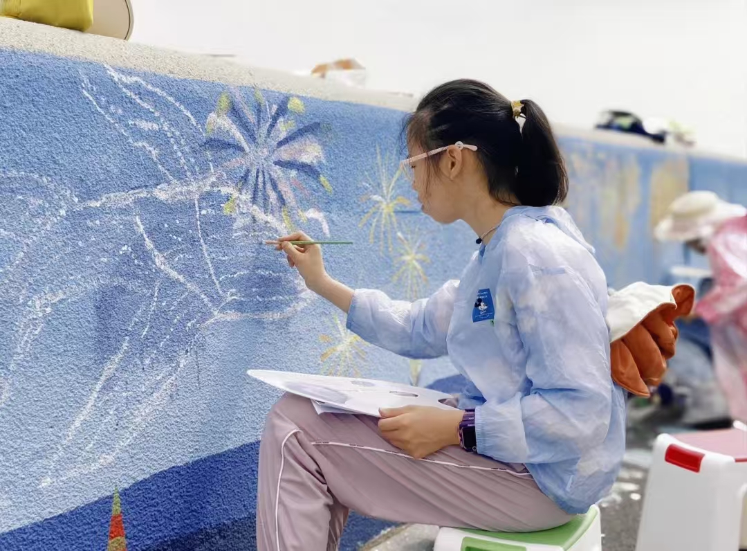 Students create vibrant graffiti along the Baoshan riverside wall.jpg