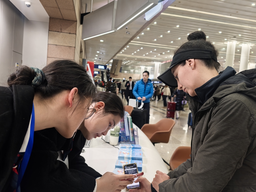 An international visitor seeks assistance at the information desk.jpg