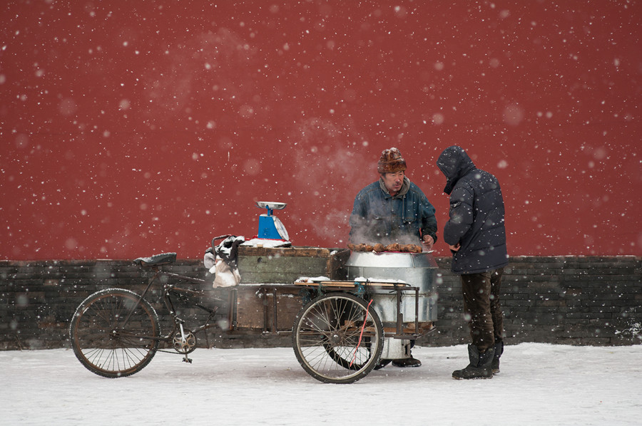 A street vendor selling roasted sweet potatoes amid the falling snow.jpg