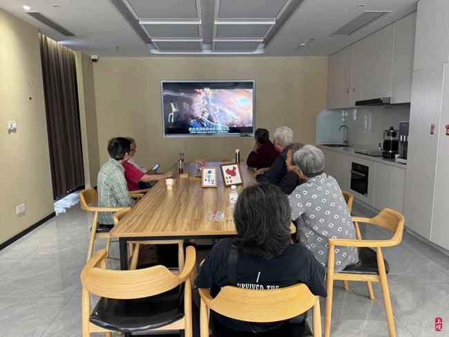 A group of elderly people watch films while enjoying tea in air-conditioned rooms at Home Furuili in Jing