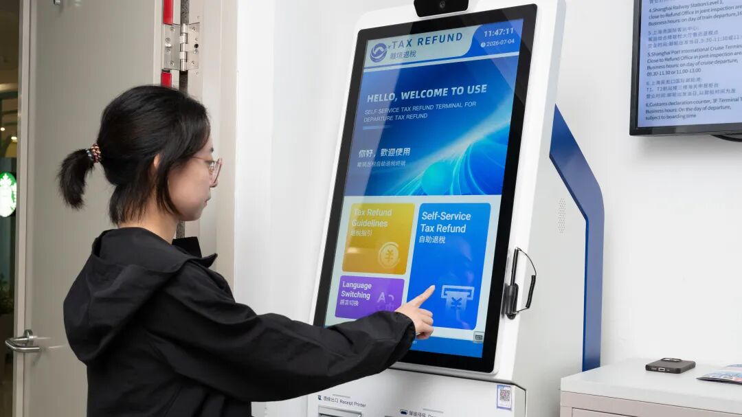 A traveler processes a tax refund at a self-service terminal..jpg