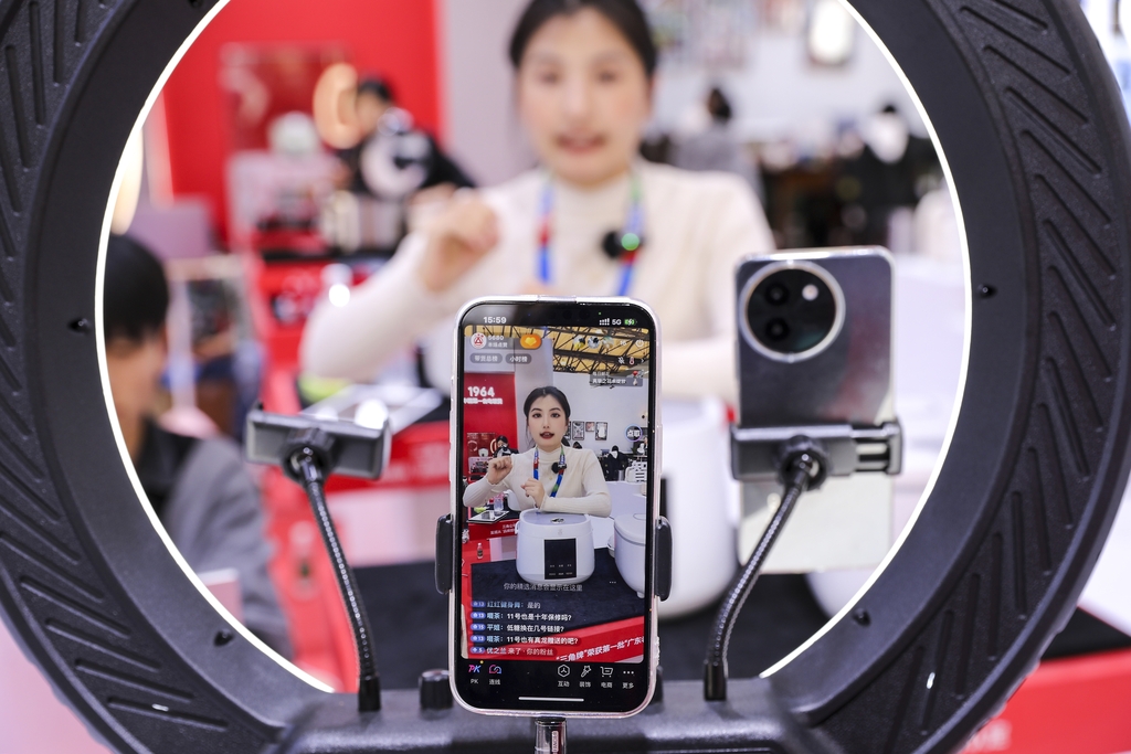 A woman is livestreaming to sell home appliances at The Appliance & Electronics World Expo (AWE) 2025..jpg