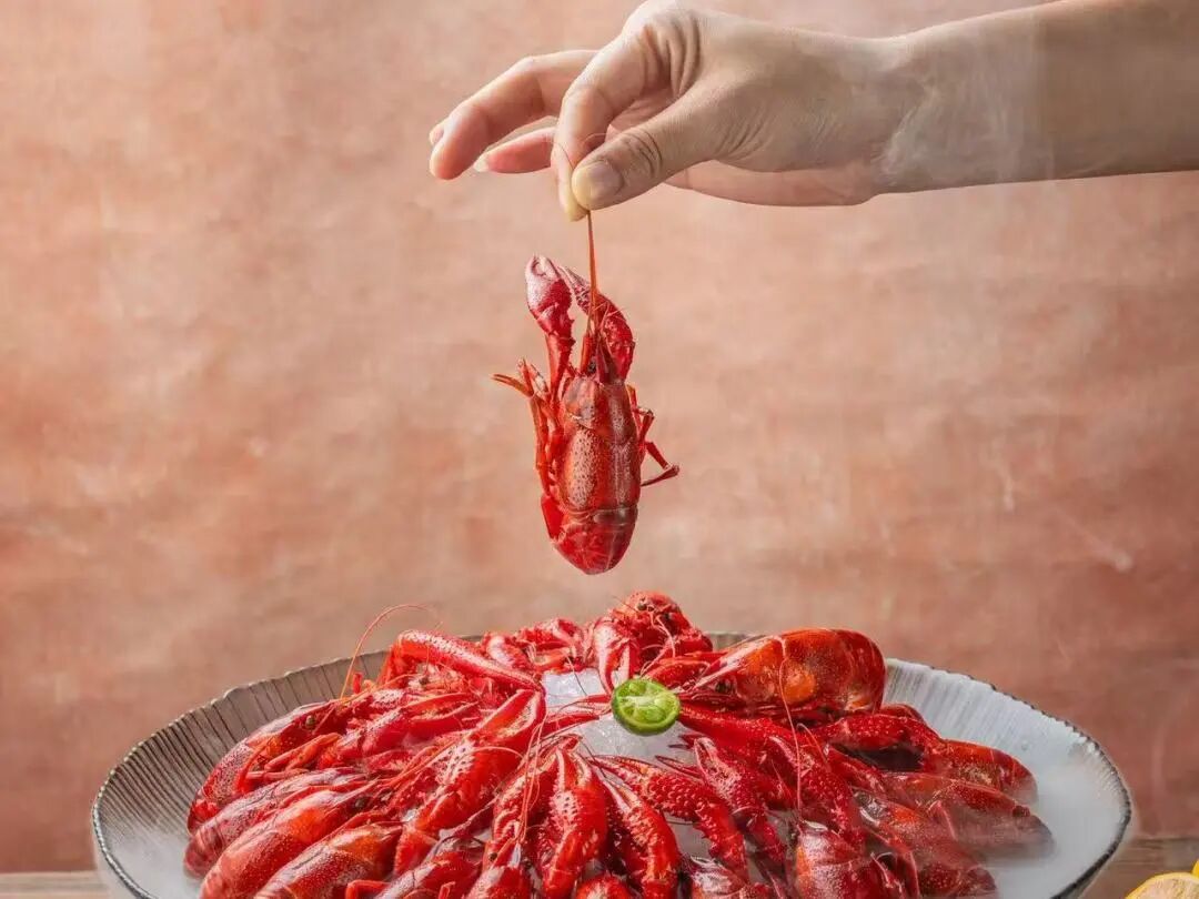 A diner picks up a crayfish by hand at Huxiaopang Shanghai Crayfish..jpg