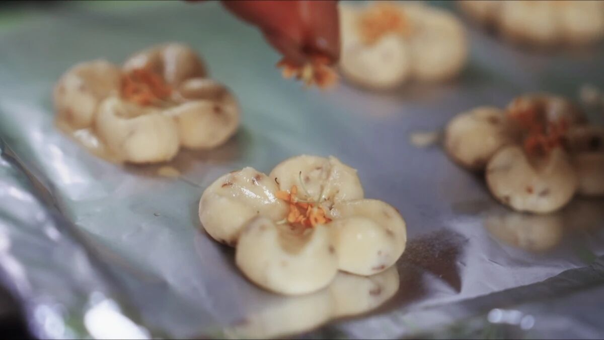Flower-shaped cookies are adorned with golden osmanthus petals.jpg
