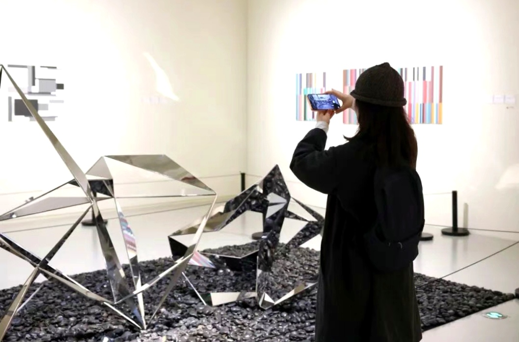 A visitor photographs an artwork at the exhibition.jpg