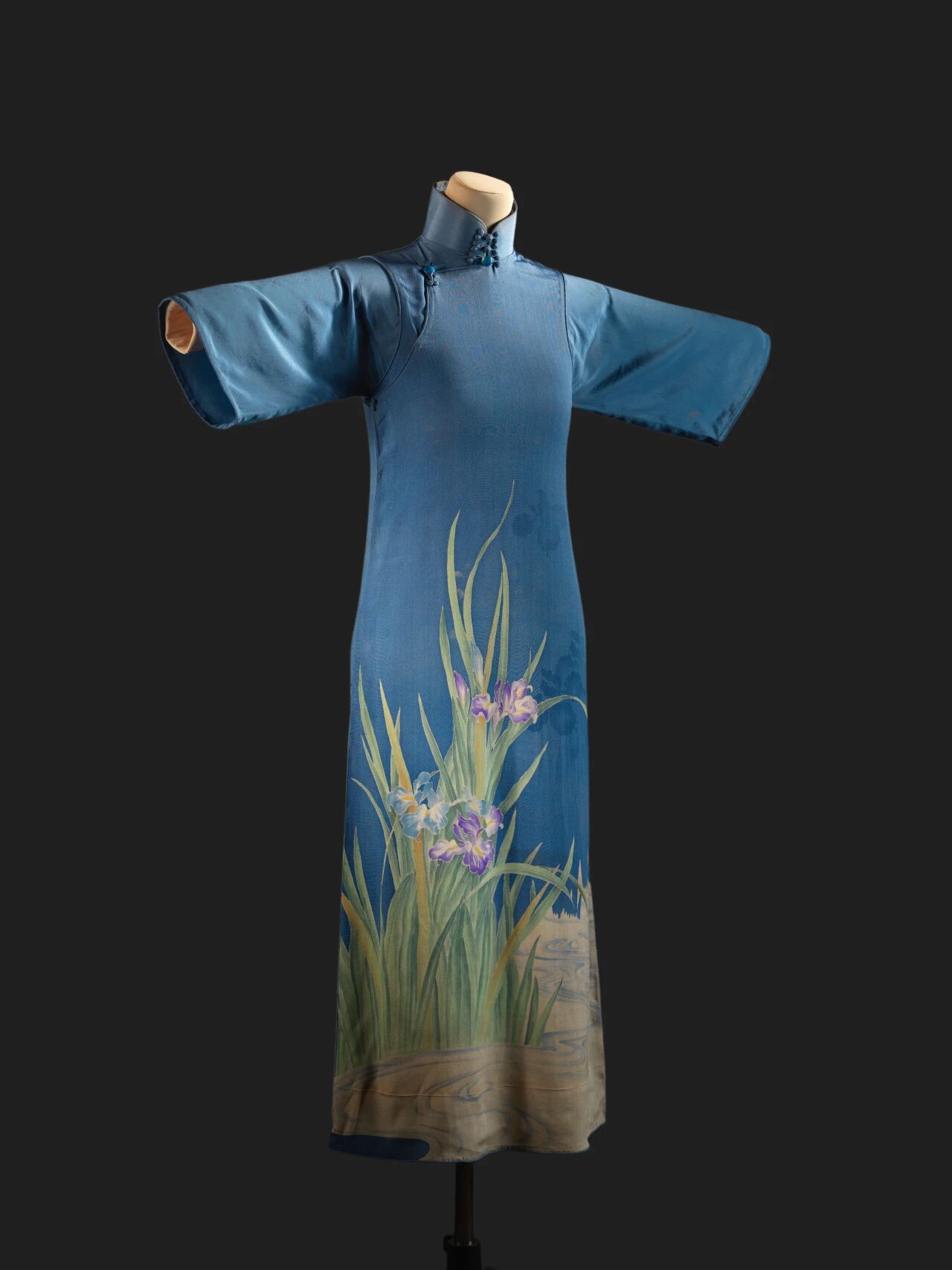 A blue crepe qipao with painted iris patterns from the 1920s, part of Jeff Chang