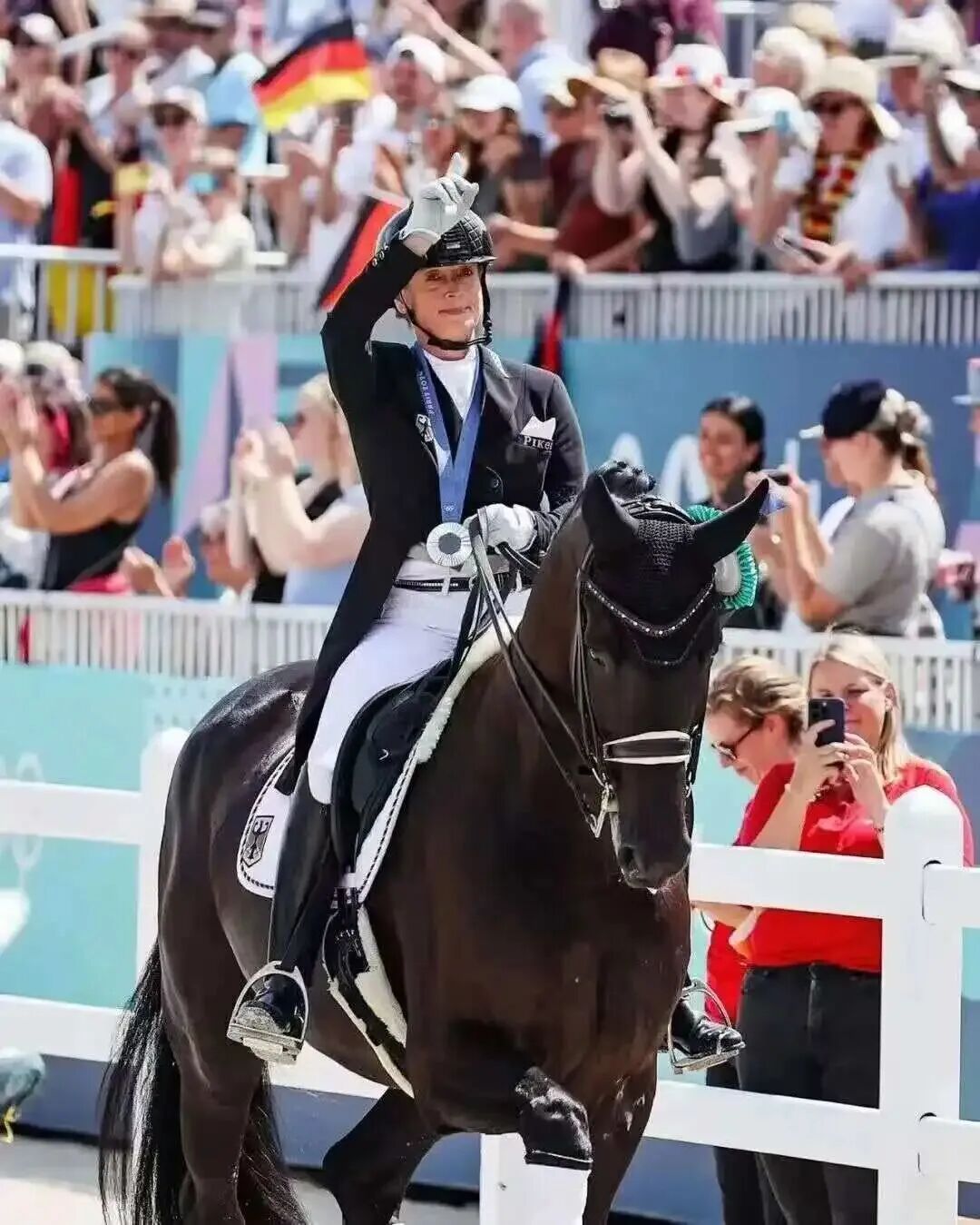 Isabell Werth waves to the crowd from the saddle.jpg