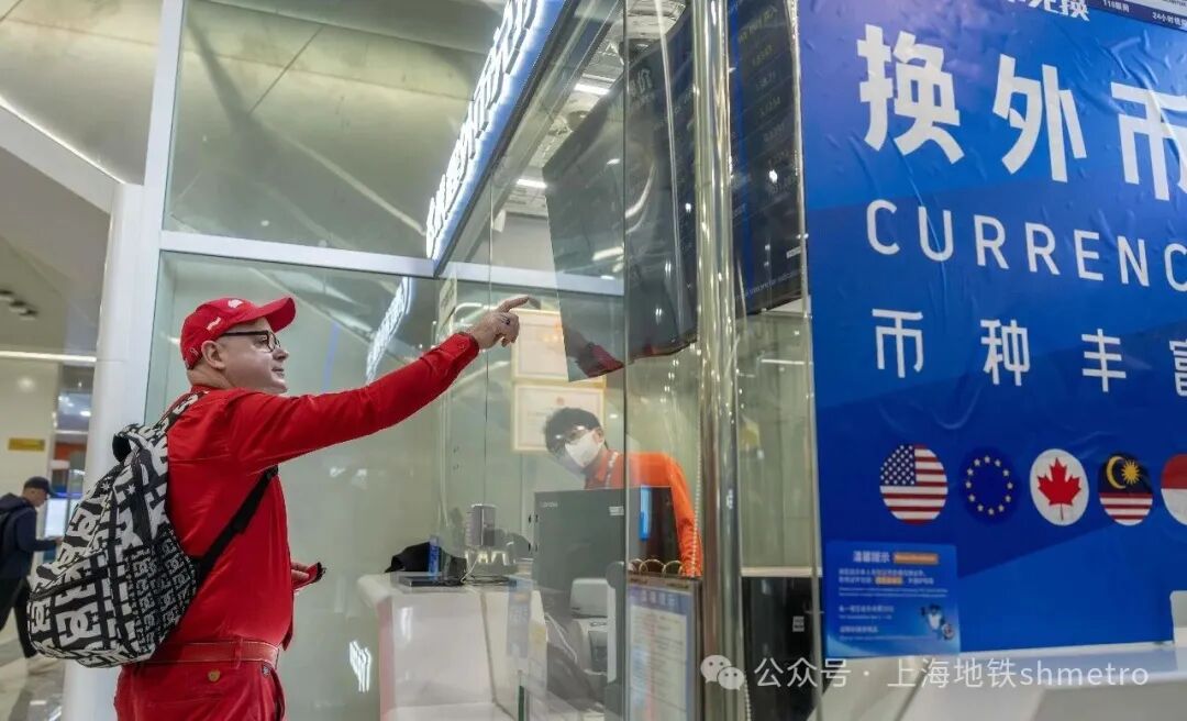 A foreign visitor inquires about currency exchange at the service counter.jpg